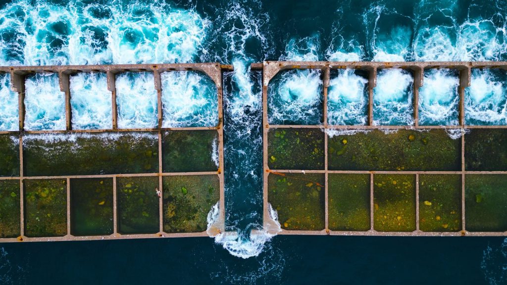 Top-down aerial image (90°) of the Piraeus cruise ship pier extension under construction, showing waves crashing against the pier, captured for Aerial Video services by Perigon Perspective.
